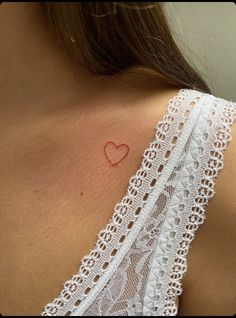 a woman with a heart tattoo on her chest