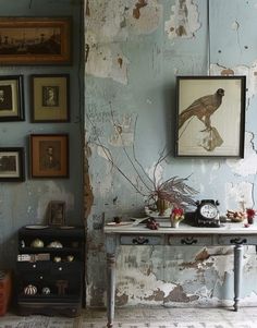 an old room with peeling paint and pictures on the wall