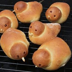 bread shaped like animals on a grill with toothpicks sticking out of their mouths