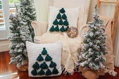 christmas trees are sitting on the floor in front of a chair