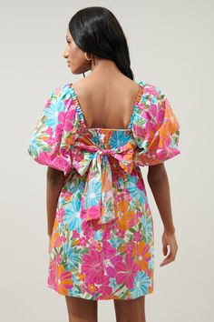 Get your bold, bright, and beautiful on in this fun-loving, tropical floral print dress. A cohesive mix of vibrant florals work together to shape the Marion mini. Oversized puff sleeves billow to frame a square neckline and fitted bodice. Princess seams help to hug natural curves, along with a tie back bow. A smocked panel at back makes for easy accessibility. A high waistline creates a babydoll silhouette with a flowy mini skirt.- Oversized sleeves- Smocked back- Tie back detail- Poplin- Color: Summer Mini Dress In Pink With Vibrant Print, Vibrant Floral Mini Dress For Beach, Summer Pink Mini Dress With Vibrant Print, Beach Mini Dress With Vibrant Print, Bright Summer Dresses, Bright Clothes, Vibrant Floral Print Mini Dress, Aesthetic Hoodies, Vibrant Florals