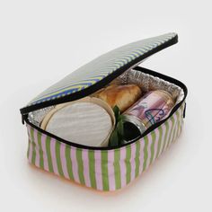 an open lunch bag filled with food on top of a white tablecloth covered floor