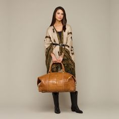 Built with Lucchese's own giant American alligator, this signature duffle totes your essentials in first class style. The fold-end construction allows for maximum packing space, which includes natural, water-resistant canvas lining, an interior zipper pocket and two open storage slots. Luxury Cognac Tote Travel Bag, Green Leather Duffle Bag With Luggage Sleeve, Luxury Duffle Bag With Luggage Sleeve For On-the-go, Luxury Leather Duffle Bag For On-the-go, Leather Duffle Bag With Zipper For On-the-go, Crocodile Duffle Bag, American Alligator, Handcrafted Boots, Handmade Boot