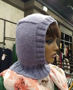 a mannequin's head wearing a purple knitted hat in a clothing store