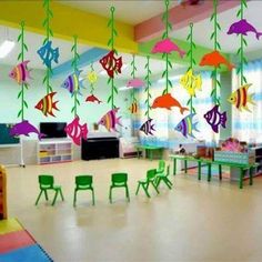 colorful fish hanging from the ceiling in a child's playroom with green chairs