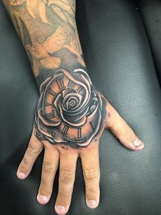 a person's hand with a tattoo on it and a rose in the middle