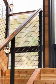 a stair case with metal railing and wood handrails