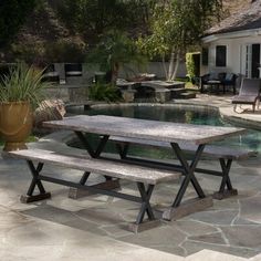 a table and bench in front of a pool