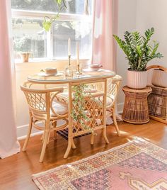 a dining room table and chairs in front of a large window with pink drapes