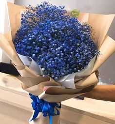 a bouquet of blue flowers sitting on top of a table