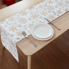 a white plate and silverware sitting on top of a wooden table