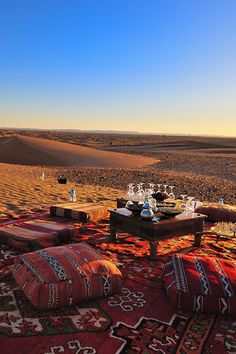 an outdoor area with rugs and tables in the desert