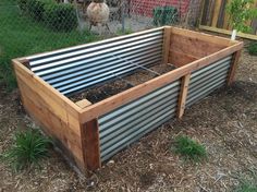 a raised garden bed with metal slats on the sides and wood in the middle