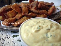 a plate full of fried food next to a bowl of dip