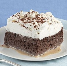 a piece of chocolate cake on a plate with a fork and spoon next to it