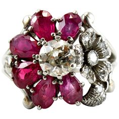 An unusual Ruby and Diamond Cluster Ring, ca. 1940s. Centring an old-cut diamond of ca. 0.85ct (ca. I/VS1), surrounded by six ruby petals, accentuated by another flower studded with diamonds. Ring size 8 (can be altered). Flower Cluster Ring, Vintage Cluster Ring, Ruby Flower, Yellow Gold Cocktail Ring, Sapphire Cocktail Ring, Antique Jewelry Rings, Flower Cluster, Bridal Wedding Rings, Diamond Cocktail Rings