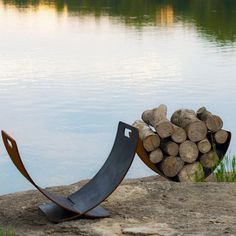 two pieces of wood sitting on top of a rock next to a body of water