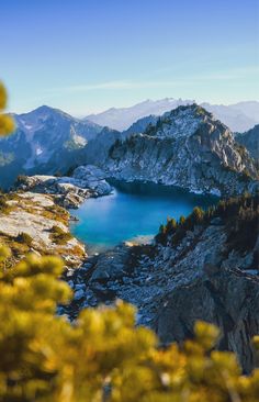 a lake surrounded by mountains and pine trees