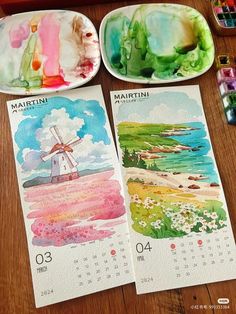 two calendars with watercolor paintings on them