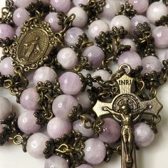 Handmade traditional Catholic 5 decade rosary using natural purple kunzite smooth stone round beads. Antique bronze scalloped flower bead caps on every bead. Antique bronze Ornate Flower Miraculous Medal center with St. Benedict Crucifix. All beads are 7mm. Designed to be used and/or displayed. Measures about 26" long. This rosary would make a beautiful gift for a baby shower, Baptism, First Communion, Confirmation, or any other special event or occasion. Comes in a beautiful black velvet pouch. Beautiful Rosaries, Antique Rosary, Chaplet Rosary, Decade Rosary, St Benedict, The Rosary, Rosary Catholic, Gadgets And Gizmos, Miraculous Medal