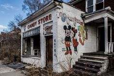 an old run down building with mickey mouse paintings on it