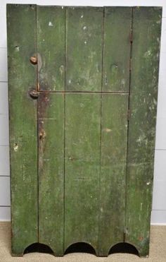 an old green wooden cabinet with metal handles