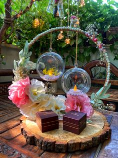 two chocolates sitting on top of a wooden table next to some flowers and plants