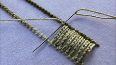 a close up of a knitting needle with yarn on the side and another thread in the middle