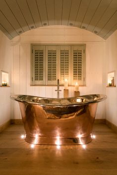 a bathtub with candles on the floor in a bathroom