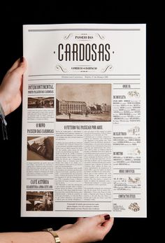 a person holding up a newspaper with the word cardosas written in front of it