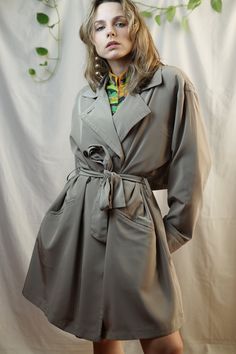 Vintage classic khaki beige trench coat for women. Adjustable waist with a belt, loose and comfortable fit, and button closure. Simple and minimalistic look. Thick shoulder pads inside. Perfect for oversized look! Manufactured probably in the late 90's/early 2000's. The model in the photo wears size Small and she is 161 cm / 5' 3" tall.  Vintage condition: PERFECT 10/10 (pre-loved, but no flaws) Material: 100% polyester Size: 16 on the tag; XL from the measurements Armpit to armpit: 128 cm / 50, Oversized Belted Beige Outerwear, Oversized Beige Belted Outerwear, Khaki Belted Outerwear For Spring, Belted Khaki Outerwear For Spring, Spring Khaki Outerwear With Belted Cuffs, Oversized Beige Raincoat For Spring, Solid Color Long Raincoat For Spring, Spring Beige Raincoat With Pockets, Spring Long Raincoat