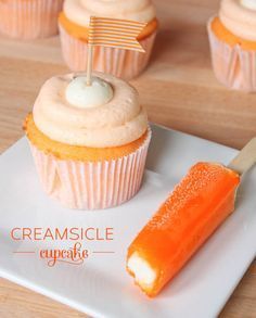 cupcakes with frosting and a flag on top are sitting on a plate