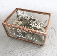 a glass box filled with flowers on top of a table