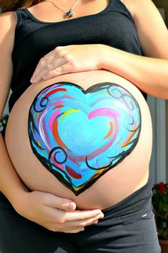 a pregnant woman's belly with a painted heart on it