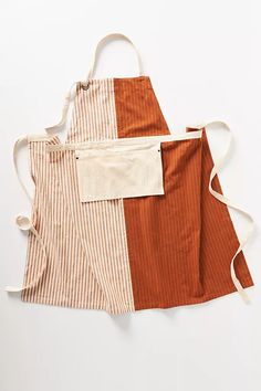 two aprons that have different colors on them, one is brown and the other is white