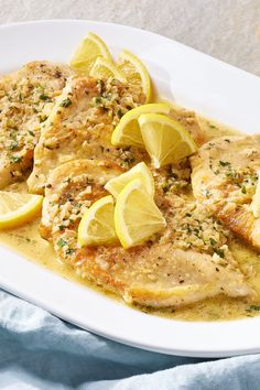 a white plate topped with chicken and lemon slices