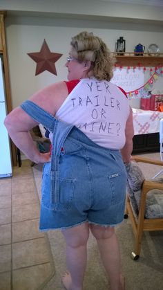 a woman with her back to the camera, wearing shorts and a t - shirt that says yes trailer or mine?