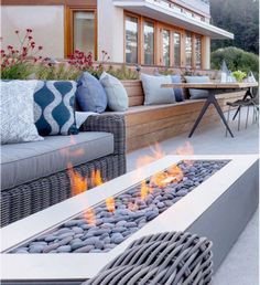 a fire pit sitting on top of a patio next to a couch and dining table