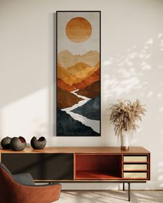 a painting hanging on the wall next to a chair and table with two vases