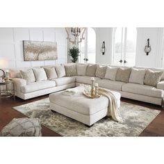 a living room with a sectional couch and ottoman