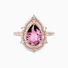 a pink tourmaline and white diamond ring with an open pear shaped center surrounded by smaller round diamonds