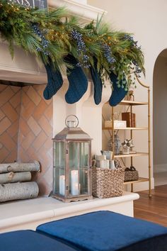 a christmas mantle with stockings hanging from it and candles in front of the mantel