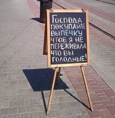 a sign that is on the side of a road next to a train track with words written in russian and english