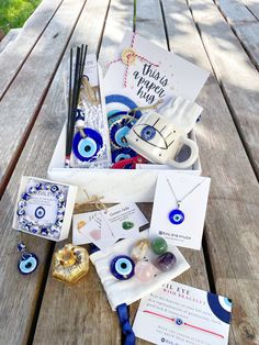 an assortment of items sitting on top of a wooden table next to cards and pens