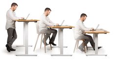 two men sitting at a table with laptops