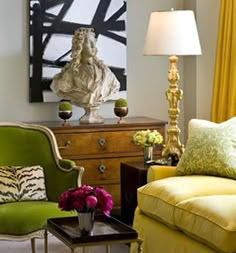 a living room filled with furniture and a statue on top of a wooden dresser next to a lamp