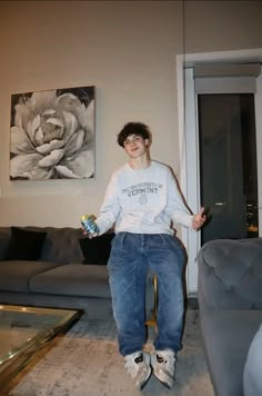 a young man sitting on top of a chair in a living room