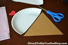 paper plate and scissors on a table with crafting supplies for valentine's day