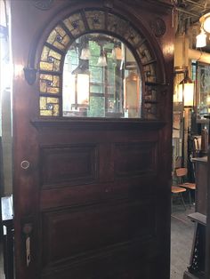 a wooden door with a mirror on the top and side panels above it in a shop