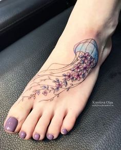 a woman's foot with a jellyfish tattoo on her left ankle and purple nail polish